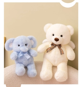 Close-up of soft plush elephant and teddy bear dolls with checkered ribbon bows