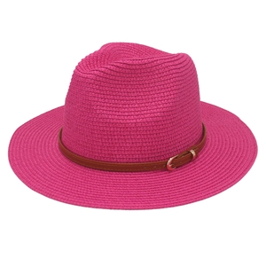Detail of rose pink woven Panama hat with brown leather belt and gold buckle accent