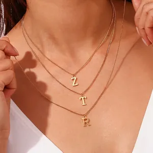 Three-layered 18k gold plated curb chain necklace with Z, T, R letter pendants on a model