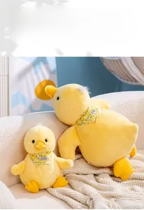 Detail of soft yellow plush duck toy with floral bib and Summer lettering on a sofa