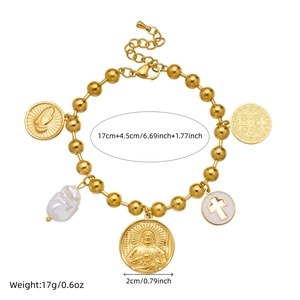 Gold beaded bracelet with religious charms and pearl on a white background