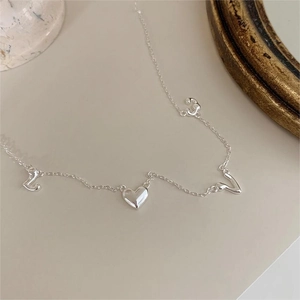 925 silver LOVE necklace with heart and letter pendants on a minimalist white surface