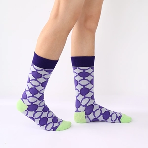 Plaid mid-calf socks in purple and gray with green accents on model in studio
