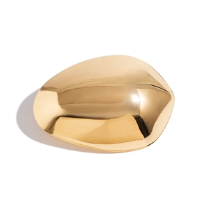 Close-up of a minimalist irregular oval golden hair clip with a mirror finish