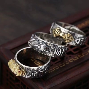 Detailed close-up of retro silver ring featuring Pixiu and engraved religious symbols