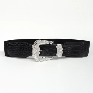 Detail of black wide waist belt featuring crocodile texture and rhinestone butterfly buckle