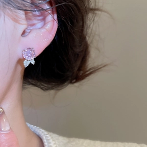 Nahaufnahme von rosa Zirkon-Blumenstecker mit feinem Blattdetail getragen von einem Modell