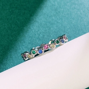 Close-up of a silver ring featuring multi-colored rainbow zircon gemstones in bezel setting