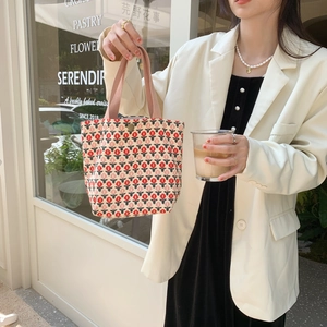 Detail of floral corduroy tote bag with tulip patterns and pink handles in street style
