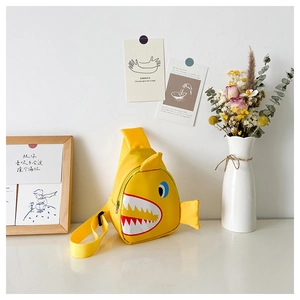 Detail of yellow shark-shaped kids chest bag featuring 3D fins and adjustable strap