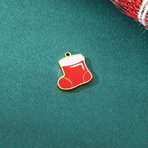 Detail of red Christmas sock charm with gold metal frame for DIY jewelry making