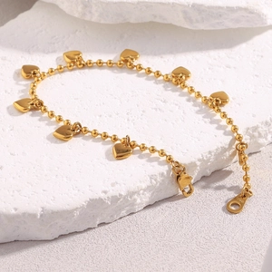 Detailed view of 18K gold plated bead chain bracelet with heart pendants on stone base