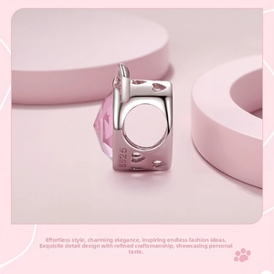 Macro shot of S925 sterling silver charm with pink gemstone and hollow heart details