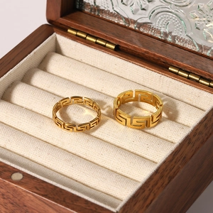 Set of two gold stainless steel rings with geometric hollow pattern on jewelry display
