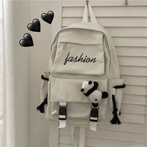 Detail of off-white canvas backpack featuring panda pendant and fashion script print