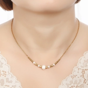 French style gold stainless steel necklace with white freshwater pearls shown on a model