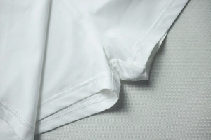 Gros plan détaillé du tissu en maille respirante blanche avec coutures à double aiguille