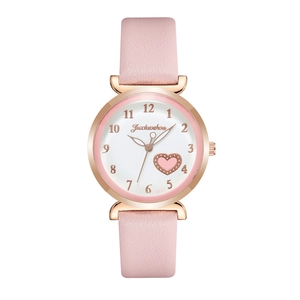 Detail view of pink leather strap and rose gold watch case with heart pattern dial