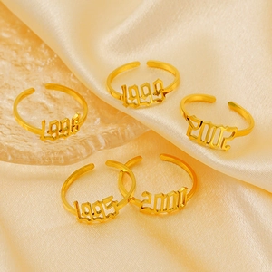 Detail of adjustable 18K gold plated year rings on satin background for luxury jewelry display