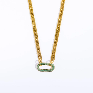 Close-up of gold Cuban chain with rectangular emerald green pave stone pendant