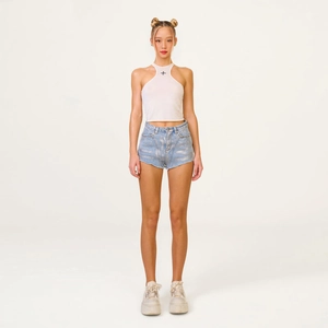 Top corto bianco allacciato al collo con pantaloncini di jeans celeste sfrangiati