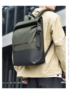 Modern waterproof backpack in green and black worn by a model in an urban setting