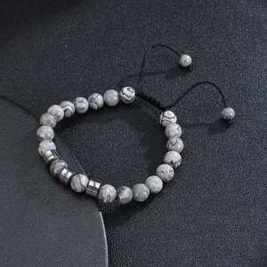 Detailed view of grey natural stone beads with custom name engravings on silver metal charms