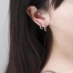 Minimalist silver round hoop earrings in high-quality stainless steel on a female model