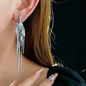 Silver wheat ear tassel earrings featuring long metallic leaf fringe on a model