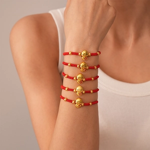 Red braided rope bracelet with golden snake lucky charm and 'Ji' character engraving