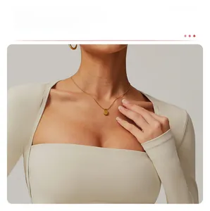 Detail of cream yoga top featuring extended cuffs for hand protection and thumbholes