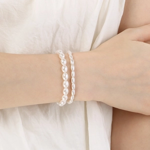 Detail of layered freshwater pearl bracelets featuring oval and rice-shaped pearls