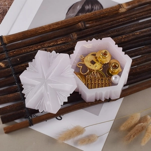 Detail of pink snowflake resin jewelry box with intricate faceted lid and golden pendants