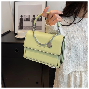 Detail of light green square bag with silver chain strap and FASHION & BAGS logo