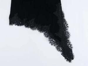 Detail eines asymmetrischen Samtkleidsaums mit feiner schwarzer Wimpernspitze