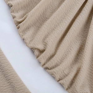 Macro shot of beige waffle textured fabric detail on a round neck bodycon dress