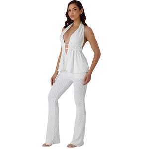 Women's sexy white two-piece set with halter wrap top and slim flare pants in textured fabric
