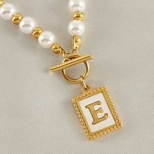 Detailansicht der vergoldeten Kette mit Buchstabe E Anhänger und weißen Perlen