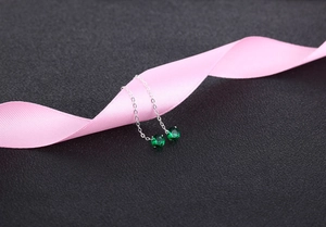 Detailed close-up of S925 silver threader earrings with green zircon on pink ribbon