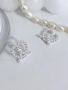 Macro shot of silver S925 heart twist knot stud earring with elegant jewelry accessories