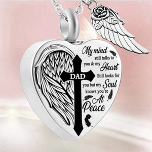 Close-up of heart-shaped Dad urn necklace with cross, angel wings, and rose details