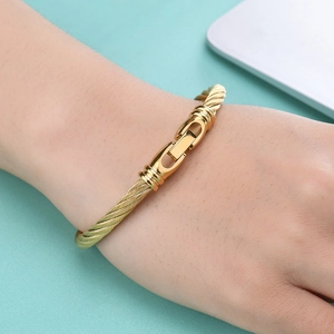 Minimalist gold cable wire twist bracelet with mechanical clasp worn on wrist