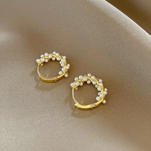 French vintage gold hoop earrings with intricately wrapped pearls on silk background