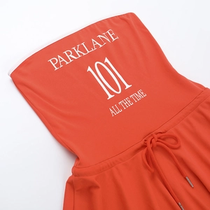 Détail du haut bandeau orange avec imprimé blanc et cordon de serrage pour ensemble plage