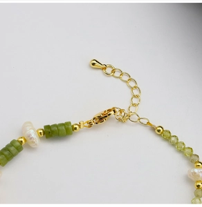 Macro shot of 18k gold plated lobster clasp and adjustable chain on pearl bracelet