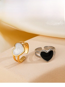 Macro view of gold and silver open rings with black and white enamel heart details