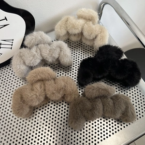 Detailed top view of five plush faux fur hair claw clips in neutral autumn colors