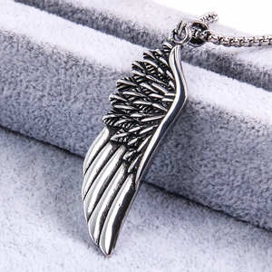 Macro detail of silver feather pendant with intricate wing texture on jewelry display