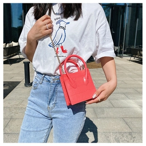 Close-up of red crocodile pattern mini square bag with golden chain and double handles