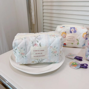 Detail of floral cotton quilted makeup bag in light beige with pink floral patterns